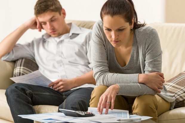 Annoyed couple calculating their finances during recession